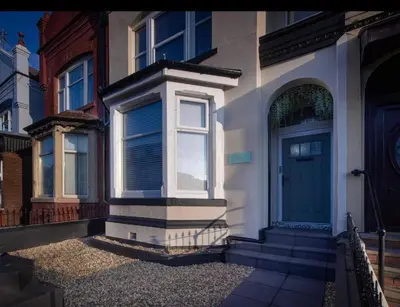 a house with a blue door on a street at Coral Boutique Apartment 3 in Blackpool