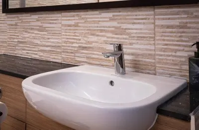 a white bathroom sink with a faucet on a wall at Coral Boutique Apartment 3 in Blackpool