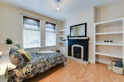 a living room with a bed and a fireplace at Poppy's Pad - Winchester Road in Liverpool