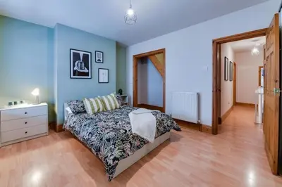 a bedroom with a bed and a dresser and blue walls at Poppy's Pad - Winchester Road in Liverpool