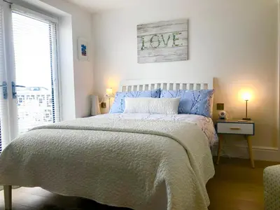 a bedroom with a large bed with blue pillows at Sunsets, Sandylands Prom Morecambe in Morecambe