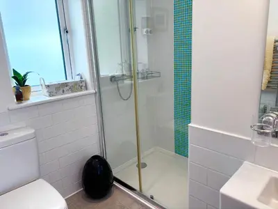 a bathroom with a shower and a toilet and a sink at Sunsets, Sandylands Prom Morecambe in Morecambe