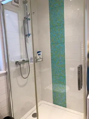 a shower with a glass door in a bathroom at Sunsets, Sandylands Prom Morecambe in Morecambe