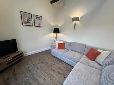 a living room with a couch and a flat screen tv at Spring Cottage in Ulverston