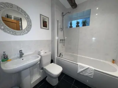 a bathroom with a sink and a toilet and a bath tub at Spring Cottage in Ulverston