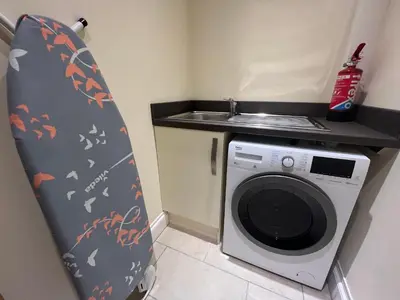a small kitchen with a washing machine and a sink at Spring Cottage in Ulverston