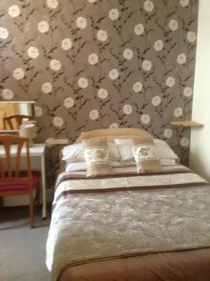 a bedroom with a bed with flowers on the wall at The Lanes in Blackpool