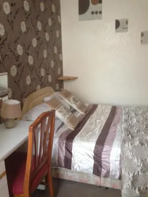a small bedroom with a bed and a desk at The Lanes in Blackpool