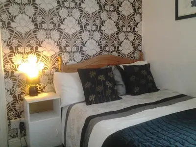 a bedroom with a bed with a lamp on a table at The Lanes in Blackpool