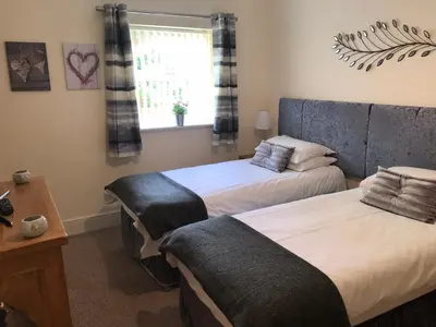a bedroom with two beds and a window at The Shelbourne in Southport