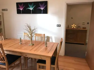 a wooden dining room table with chairs and a painting on the wall at The Shelbourne in Southport