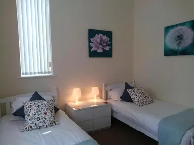 two beds in a room with two lamps on them at The Shelbourne in Southport