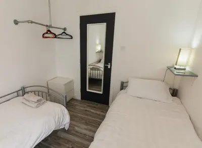 a bedroom with two beds and a mirror in it at Windsor Stays 2 in Liverpool