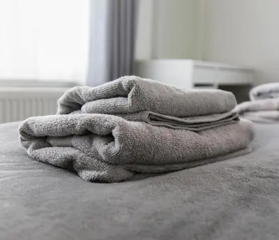a pile of towels sitting on top of a bed at Windsor Stays 2 in Liverpool