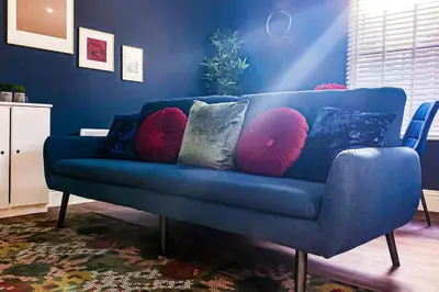 a blue couch with pillows in a living room at Velveteen by The V Group in Blackpool