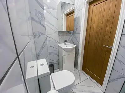 a white bathroom with a toilet and a sink at Velveteen by The V Group in Blackpool