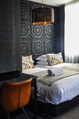 a bedroom with a bed and a table with pillows at 24 Catharine Street Hotel in Liverpool