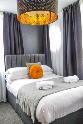 a bedroom with a bed with an orange pillow on it at 24 Catharine Street Hotel in Liverpool