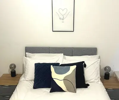 a bed with black and white pillows in a bedroom at SA Stays in Wigan