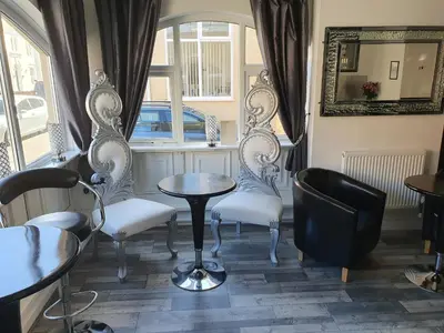 a room with two chairs and a table and a window at The Dudley Hotel in Blackpool
