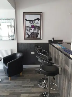 a barber shop with four barber chairs and a counter at The Dudley Hotel in Blackpool