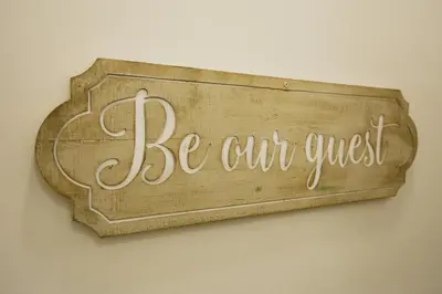 a sign that reads be our guest hanging on a wall at Windsor stays 1 in Liverpool