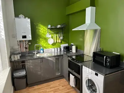 a kitchen with a sink and a washing machine at Windsor stays 1 in Liverpool