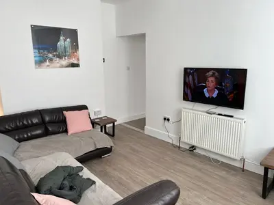 a living room with a couch and a flat screen tv at Windsor stays 1 in Liverpool