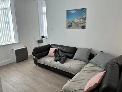 a living room with a black leather couch in a room at Windsor stays 1 in Liverpool