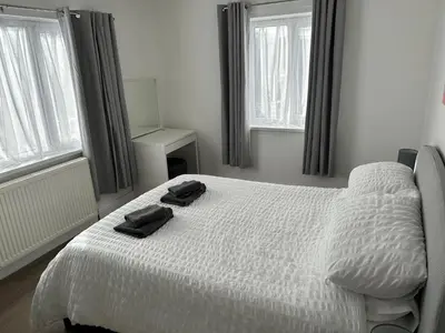 a bedroom with a white bed with two towels on it at Windsor stays 1 in Liverpool