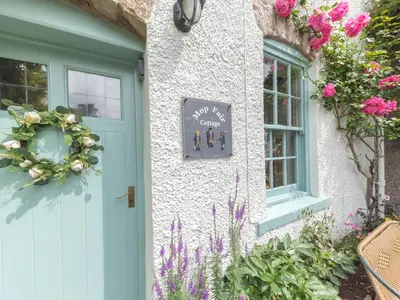 a house with a blue door and flowers at Mop Fair Sunny Garden Town Centre - Pass the Keys in Ulverston