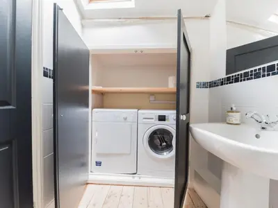 a small bathroom with a washing machine and a sink at Mop Fair Sunny Garden Town Centre - Pass the Keys in Ulverston