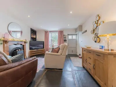 a living room with a couch and a fireplace at Mop Fair Sunny Garden Town Centre - Pass the Keys in Ulverston