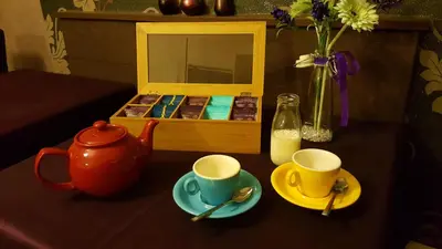 a table with two cups and a tea pot and a box of milk at Gabrielles in Blackpool