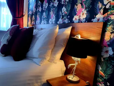 a bed with pillows and a lamp on a table at Gabrielles in Blackpool