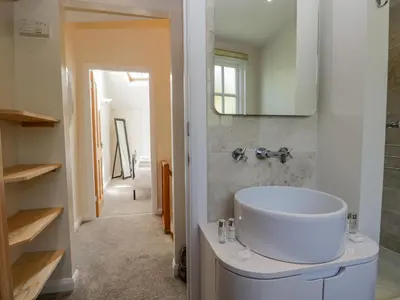 a bathroom with a white sink and a mirror at Endgill Cottage in Ulverston