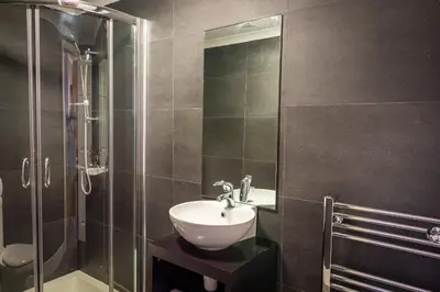 a bathroom with a sink and a glass shower at Lakeland Lodge in Carnforth