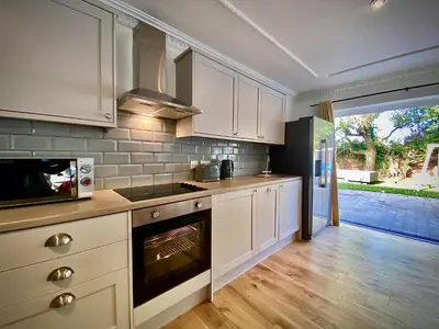 a kitchen with white cabinets and an oven at Beautiful Hot Tub Suite in Lytham St Annes in Lytham St Annes