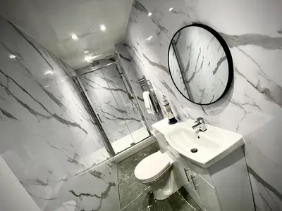 a white bathroom with a sink and a mirror at Beautiful Hot Tub Suite in Lytham St Annes in Lytham St Annes