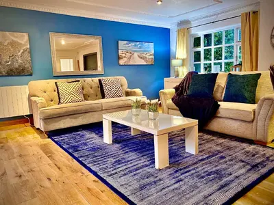 a living room with a couch and a table at Beautiful Hot Tub Suite in Lytham St Annes in Lytham St Annes