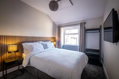 a bedroom with a large white bed and a window at Dalton Sq Apartments in Lancaster