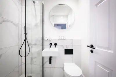 a white bathroom with a toilet and a shower at Dalton Sq Apartments in Lancaster