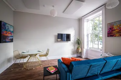 a living room with a blue couch and a table at Dalton Sq Apartments in Lancaster