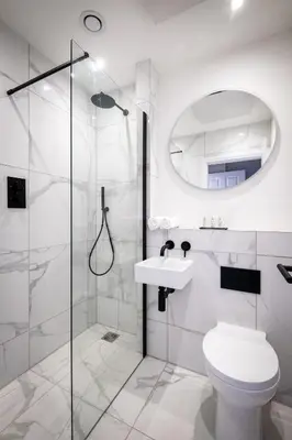 a white bathroom with a shower and a toilet at Dalton Sq Apartments in Lancaster