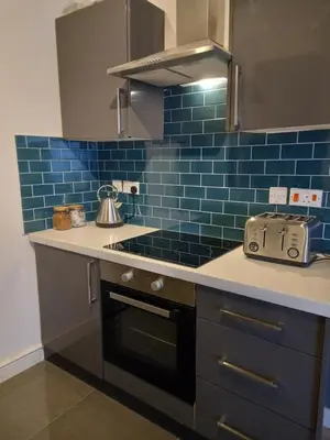 a kitchen with blue tiles on the wall at L2 Apartments- City Center- 2 bed in Liverpool
