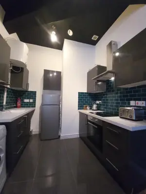 a kitchen with black and white counters and a refrigerator at L2 Apartments- City Center- 2 bed in Liverpool