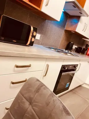 a kitchen counter with a microwave and a chair at Luxury Suite 3 bed apartment sleeps 6-8 in Blackpool