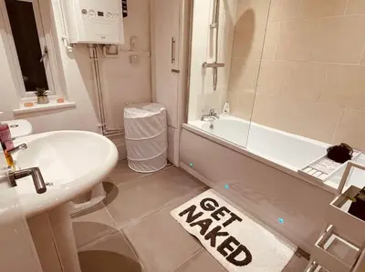 a bathroom with a white tub and a sink and a bath tub at Luxury Suite 3 bed apartment sleeps 6-8 in Blackpool