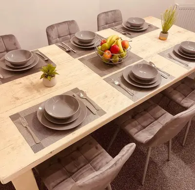 a wooden table with plates and a bowl of fruit at Luxury Suite 3 bed apartment sleeps 6-8 in Blackpool