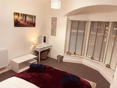 a bedroom with a bed and a desk and a window at Luxury Suite 3 bed apartment sleeps 6-8 in Blackpool